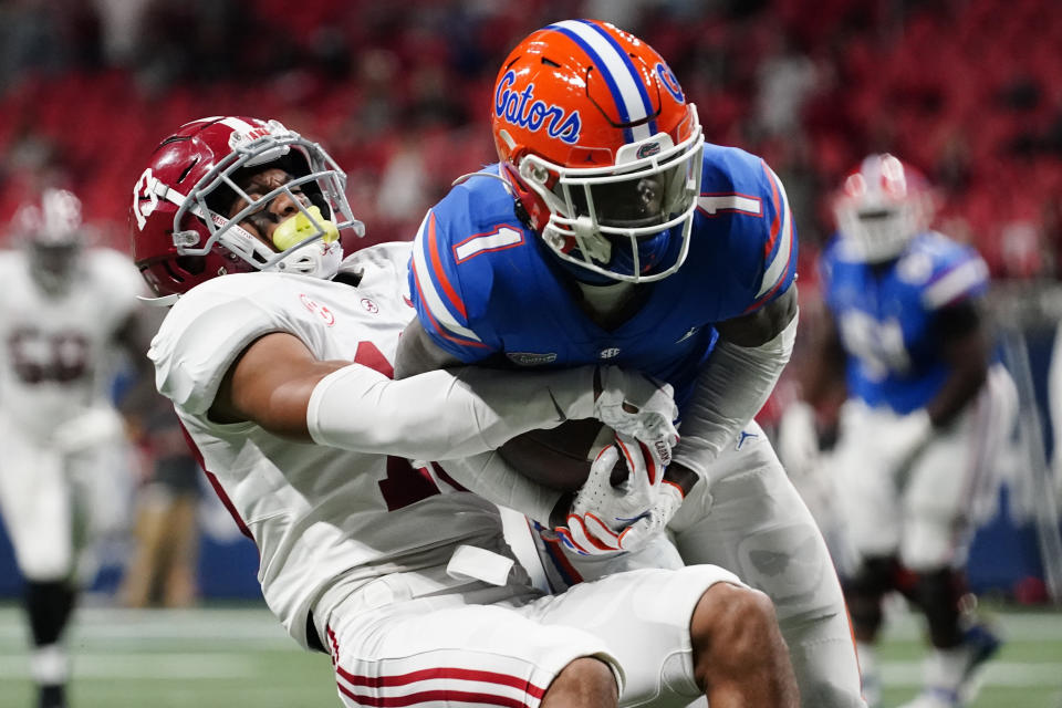 Alabama defensive back Malachi Moore (13) hits Florida wide receiver Kadarius Toney (1) during the first half of the Southeastern Conference championship NCAA college football game, Saturday, Dec. 19, 2020, in Atlanta. (AP Photo/Brynn Anderson)