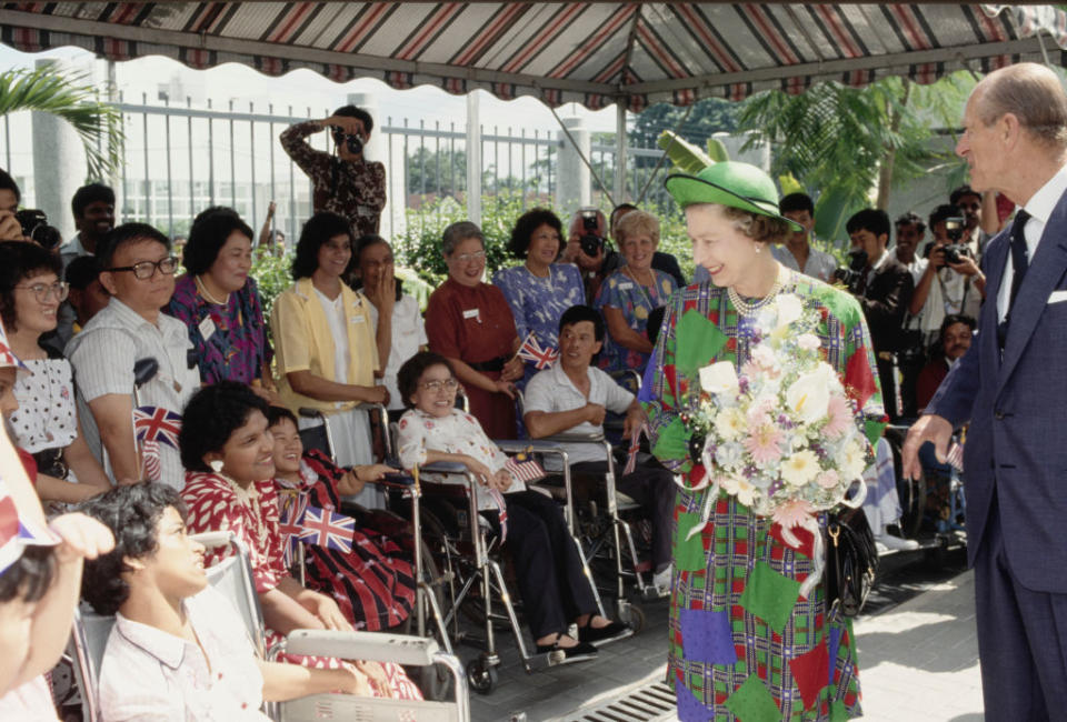 Queen Elizabeth II and Prince Philip greet well-wishers during a walkabout in Kuala Lumpur, Malaysia, Oct. 17, 1989.<span class="copyright">Tim Graham Photo Library via Getty Images</span>