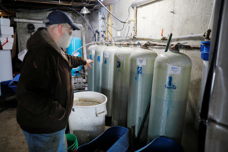 Dairy farmer Fred Stone points to the water filtration system he installed after discovering the soil, hay, and the milk from the cows contain extremely high levels of PFAS chemicals resulting from a 1980's state program to fertilize the pastures with treated sludge waste and making the milk unsuitable for sale, at the Stoneridge Farm in Arundel, Maine, U.S., March 11, 2019. Picture taken March 11, 2019. REUTERS/Brian Snyder