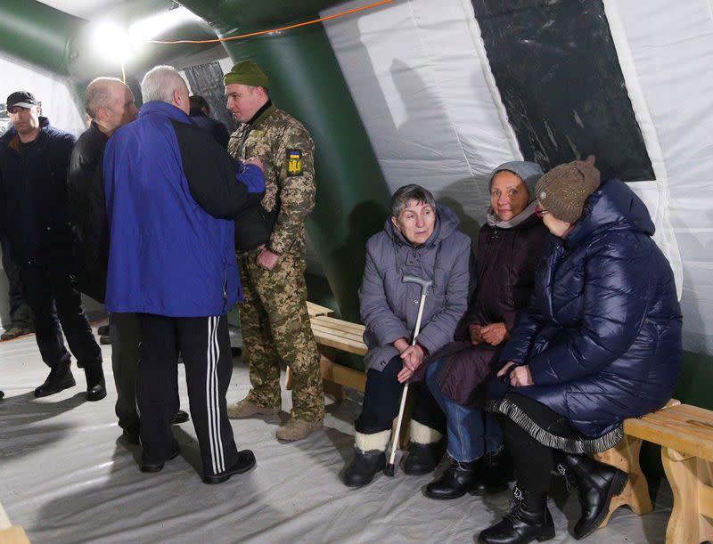 Ukrainian citizens gather in a tent after the exchange of prisoners of war between Ukraine and the separatist republics near the Mayorsk crossing point in Donetsk region