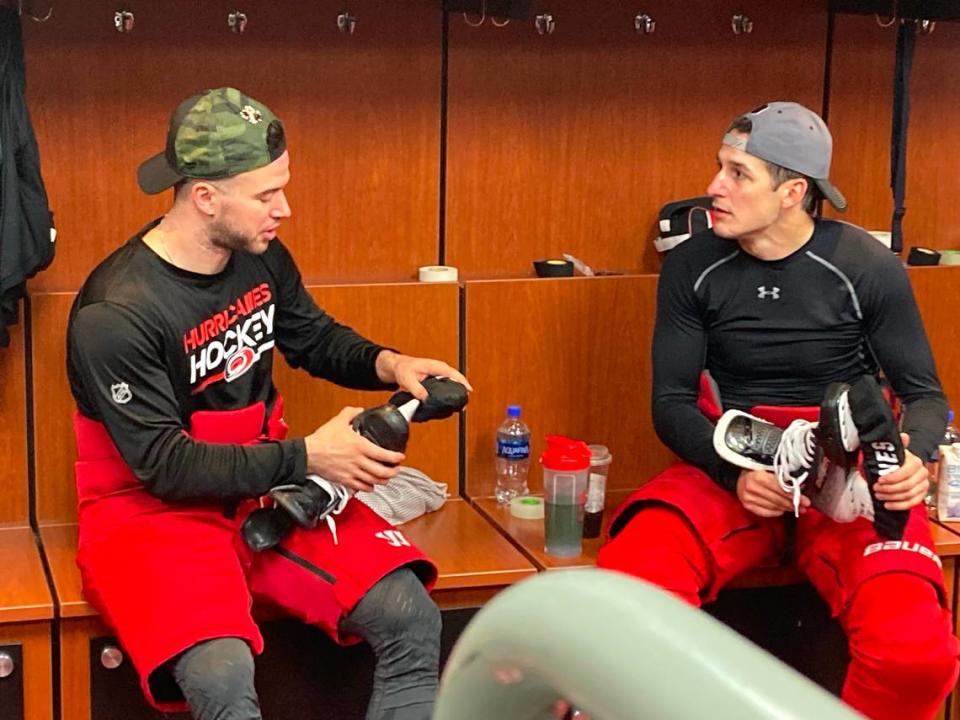 Carolina Hurricanes defensemen Tony DeAngelo, left, and Brady Skjei talk things over after practice at PNC Arena during the Stanley Cup playoffs on April 24, 2024.