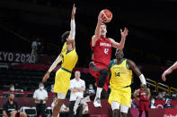 Germany's Andreas Obst (42) drives to the basket between Australia's Matisse Thybulle (10) and Duop Reath (14) during a men's basketball preliminary round game at the 2020 Summer Olympics, Saturday, July 31, 2021, in Saitama, Japan. (AP Photo/Charlie Neibergall)