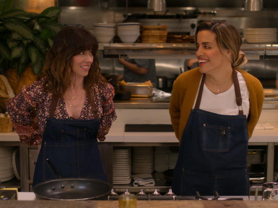Linda Cardellini and Natalie Morales in aprons in cooking scene in "Dead to Me"