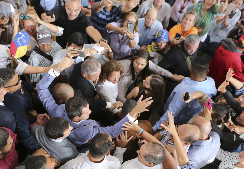 National Assembly President Juan Guaido greets supporters as he arrives to meet with residents in the Hatillo municipality of Caracas, Venezuela, Thursday, March 14, 2019. Guaido has declared himself interim president and demands new elections, arguing that President Nicolas Maduro's re-election last year was invalid. (AP Photo/Fernando Llano)