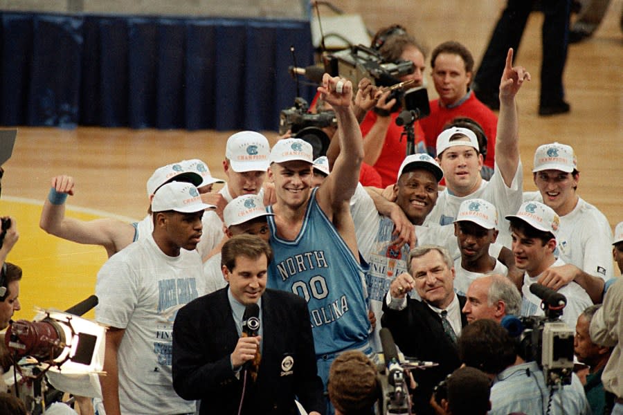 FILE – In this April 5, 1993, file photo, North Carolina coach Dean Smith at front center right, points as he celebrates a 77-71 win against Michigan in the NCAA Final Four championship basketball game in New Orleans. At center is Eric Montross (00). The game wasn’t settled until Michigan’s Chris Webber called a timeout the Wolverines didn’t have with 11 seconds to go. ″You can call it lucky, you can call it fortunate, but it still says NCAA championship,″ Smith said. (AP Photo/Bob Jordan, File)