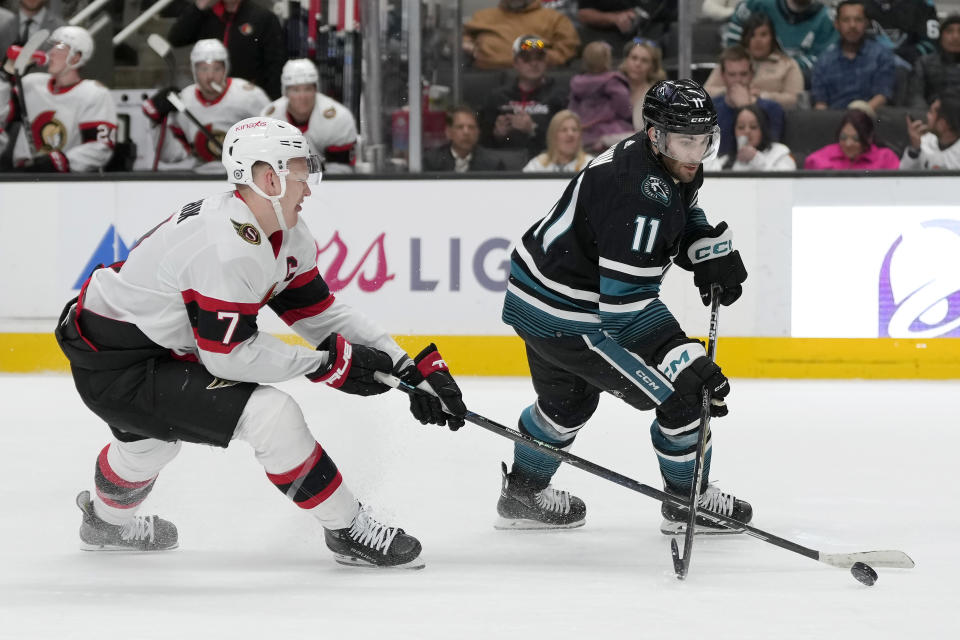 Ottawa Senators left wing Brady Tkachuk (7) reaches for the puck in front of San Jose Sharks center Luke Kunin (11) during the first period of an NHL hockey game in San Jose, Calif., Saturday, March 9, 2024. (AP Photo/Jeff Chiu)