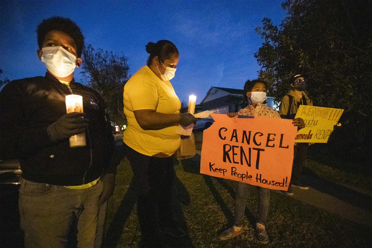 Lakewood, CA - December 16:  Kennia Viera, center, of Los Angeles, who is a single mom, unemployed and in danger of being evicted at the end of January, protests with her kids, Florisabella Houston-Viera, 7, second from right, and Enrique Houston-Viera, 9, left, after speaking at a protest for tenants in danger of eviction because of the financial fallout of the coronavirus pandemic. The protestors take part in a ``posada'' protest outside the home of Assembly Speaker Anthony Rendon, D-Lakewood, to urge him to support AB 15 and AB 16 in on Wednesday, Dec. 16, 2020 in Lakewood, CA. The pair of bills would extend eviction protections for tenants and ensure COVID-19 debt relief for struggling tenants and landlords. Demonstrators, who also protested outside Rendons future office, re-enacted Joseph and Mary's journey from Nazareth to Bethlehem in search of safe refuge so Mary could give birth to Jesus. (Allen J. Schaben / Los Angeles Times via Getty Images)