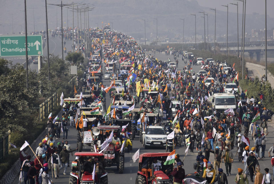 FILE - In this Tuesday, Jan. 26, 2021, file photo, farmers camping in the edges of the city participate in a tractor protest rally towards the capital during India's Republic Day in New Delhi, India. Following the protests, the mainstream and social media have come under unprecedented attacks from Prime Minister Narendra Modi’s Bharatiya Janata Party. The trigger for the clampdown was the death of a protester, Navneet Singh, when the largely peaceful rallies turned violent on Jan. 26 after a group of farmers veered from an agreed protest route and stormed New Delhi’s 17th century Red Fort. Farmer leaders condemned the violence but refused to call off the protest. Authorities say no shots were fired and that Singh died because his tractor overturned. His family alleged he was fatally shot. (AP Photo/Dinesh Joshi, File)