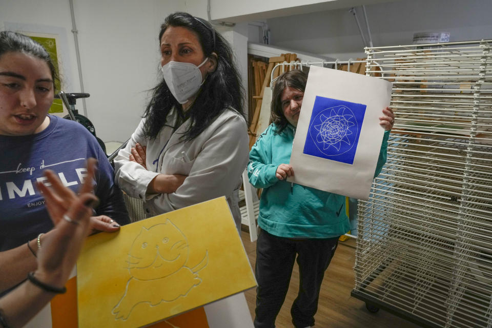 From left, Marika Pucci, Chiara Di Bartolomei and Chiara Santarelli gather inside the calcography workshop of the Chicco community of L'Arche, an International charity that helps people with intellectual disabilities, in Ciampino, near Rome, Wednesday, March 22, 2023. The findings of expert reports commissioned by L’Arche itself reveal that their founder, Jean Vanier, perverted Catholic doctrine to justify his own sexual compulsions and abuse women and that the movement he created had at its core a secret, a mystical-sexual “sect” founded for the precise purpose of hiding the sect’s deviant activities from church authorities. (AP Photo/Gregorio Borgia)