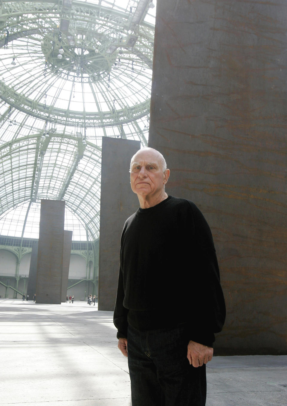 ARCHIVO - El escultor estadounidense Richard Serra posa frente a sus cinco placas monumentales el 2 de mayo de 2008, en el Museo Grand Palais de París. Serra, conocido por convertir paredes curvas de acero oxidado y otros materiales maleables en obras de arte a gran escala que ahora están repartidas por todo el mundo, murió el martes 26 de marzo de 2024 en su casa en Long Island, Nueva York. Tenía 85 años. (Foto AP/Michel Euler, archivo)