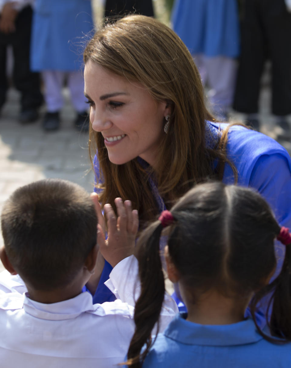 Britain's Princess Kate chats with students during her visit to a school ouside of Islamabad, Pakistan, Tuesday, Oct. 15, 2019. The Duke and Duchess of Cambridge, who are strong advocates of girls' education were greeted by teachers and children. (AP Photo/B.K. Bangash)