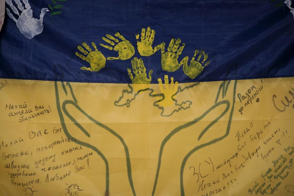 A Ukrainian flag with signed messages for the army hung on the wall of a stabilization point in Donetsk Oblast, photographed on Nov. 11, 2023. (Francis Farrell/The Kyiv Independent).