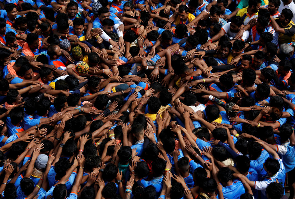 Devotees form a human pyramid to break a clay pot containing curd