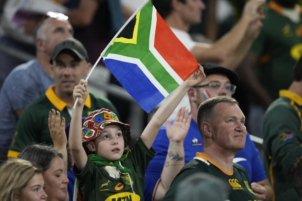 A young South Africa fan holds a flag before the Rugby World Cup Pool B match between South Africa and Tonga, at Marseille's Stade Velodrome, France Sunday, Oct. 1, 2023. (AP Photo/Pavel Golovkin)