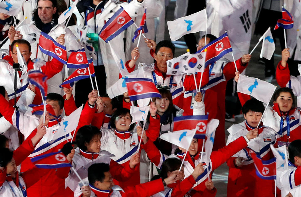 Athletes from North Korea and South Korea&nbsp;wave their flags.