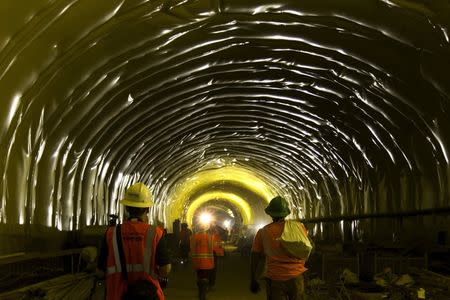 Media and workers walk in a tunnel in the East Side Access project, more than 15 stories beneath Midtown Manhattan where workers are building a new terminal for the Long Island Railroad, the United States' busiest commuter rail system, is seen during a media tour of the site in New York, November 4, 2015. REUTERS/Mike Segar