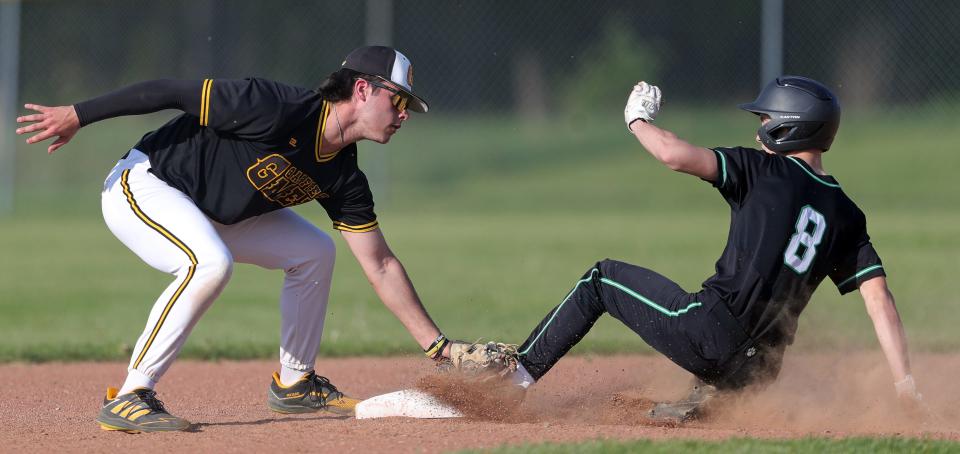 Garfield shortstop Eric Geddes, left, attempts to make the tag in time as Mogadore baserunner Devin Graham steals second base during the third inning of a high school baseball game, Wednesday, May 1, 2024, in Garrettsville, Ohio.