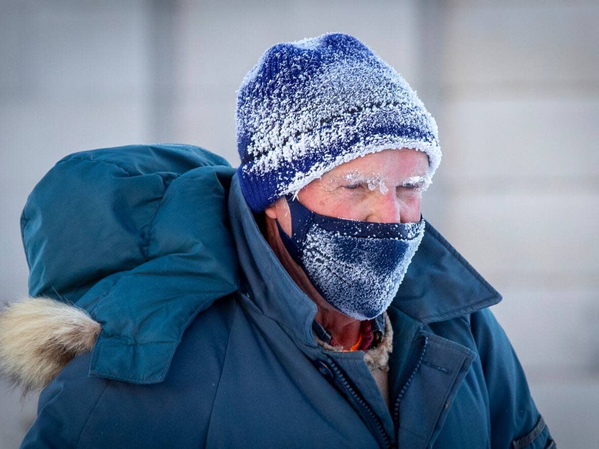 A man's face is covered with frost and a mask during a frigid morning in Kingston, Ont., last week. Extreme cold warnings have been issued for a wide swath of eastern Ontario, although not Kingston. (Lars Hagberg/The Canadian Press - image credit)