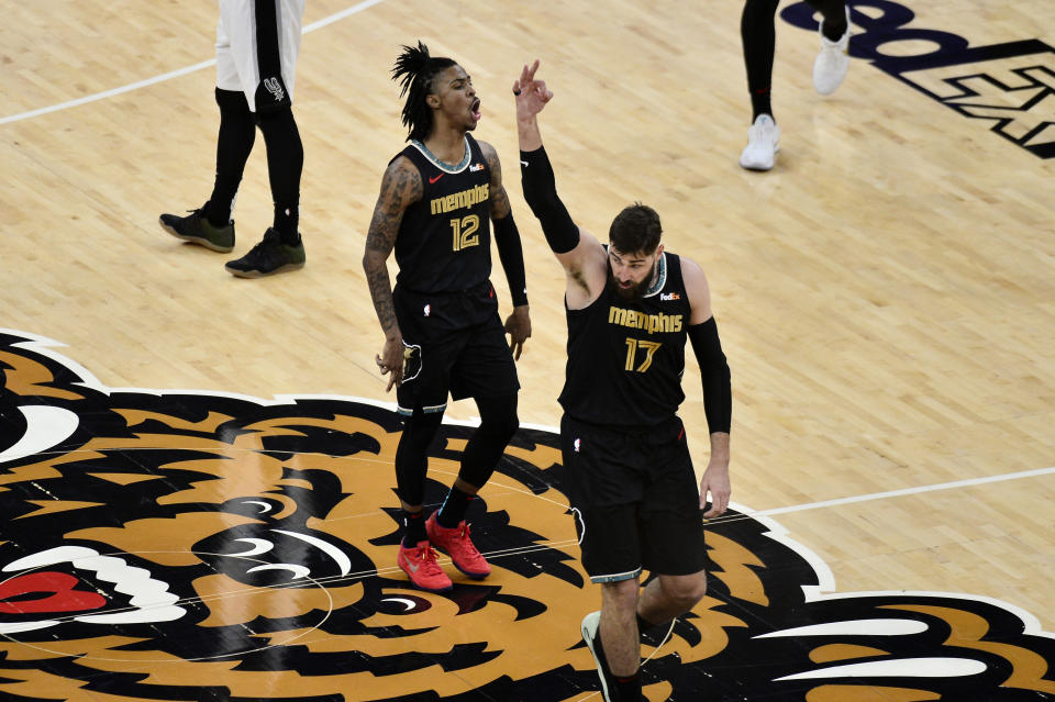 Memphis Grizzlies guard Ja Morant (12) and center Jonas Valanciunas (17) react during the first half of the team's NBA basketball Western Conference play-in game against the San Antonio Spurs on Wednesday, May 19, 2021, in Memphis, Tenn. (AP Photo/Brandon Dill)