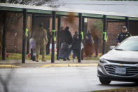 Parents escort their children Richneck Elementary School on Monday Jan. 30, 2023 in Newport News, Va. The Virginia elementary school where a 6-year-old boy shot his teacher has reopened with stepped-up security and a new administrator. (AP Photo/John C. Clark)