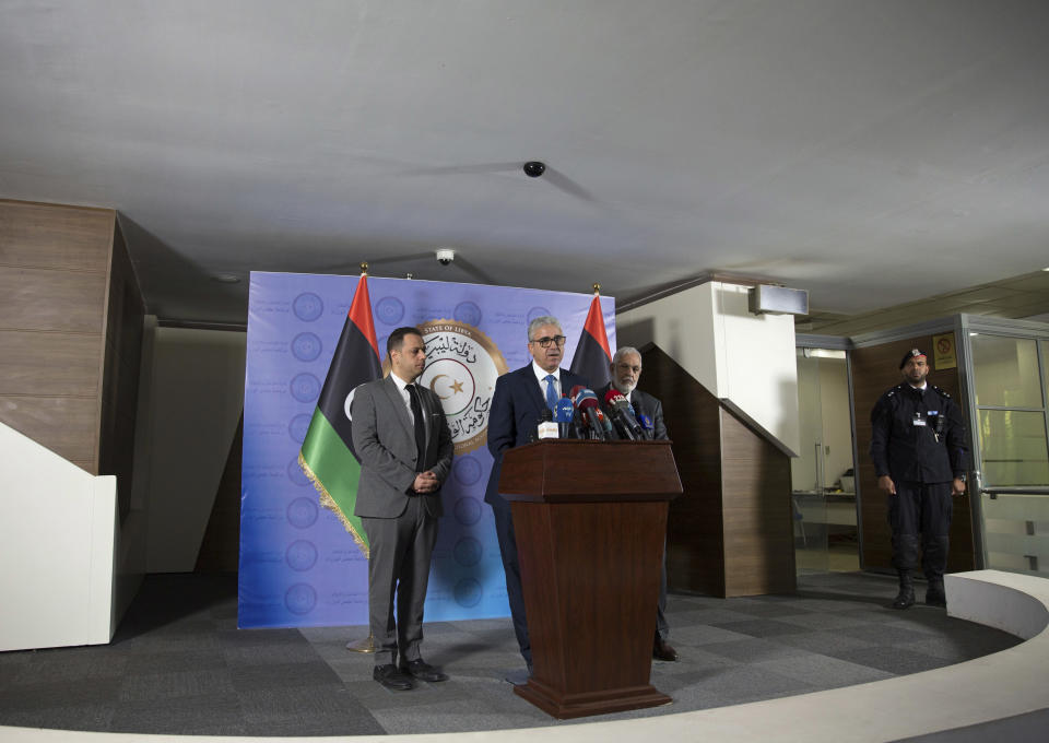 Libyan Foreign Minister Mohamed Siala, right, Interior Minister Fathi Bash Agha, center and Spokesperson for the President of the Presidency Council Mohamed el-Sallak give a press conference shortly after an attack on the foreign ministry building, in Tripoli, Libya, Tuesday, Dec, 25, 2018. Security officials said Tuesday that a suicide bomber targeted the entrance of Libya’s Foreign Ministry in Tripoli, killing several people, including a prominent militia leader. They said a second attacker was shot dead by guards before he could detonate his explosive vest. (AP Photo/Mohamed Ben Khalifa)