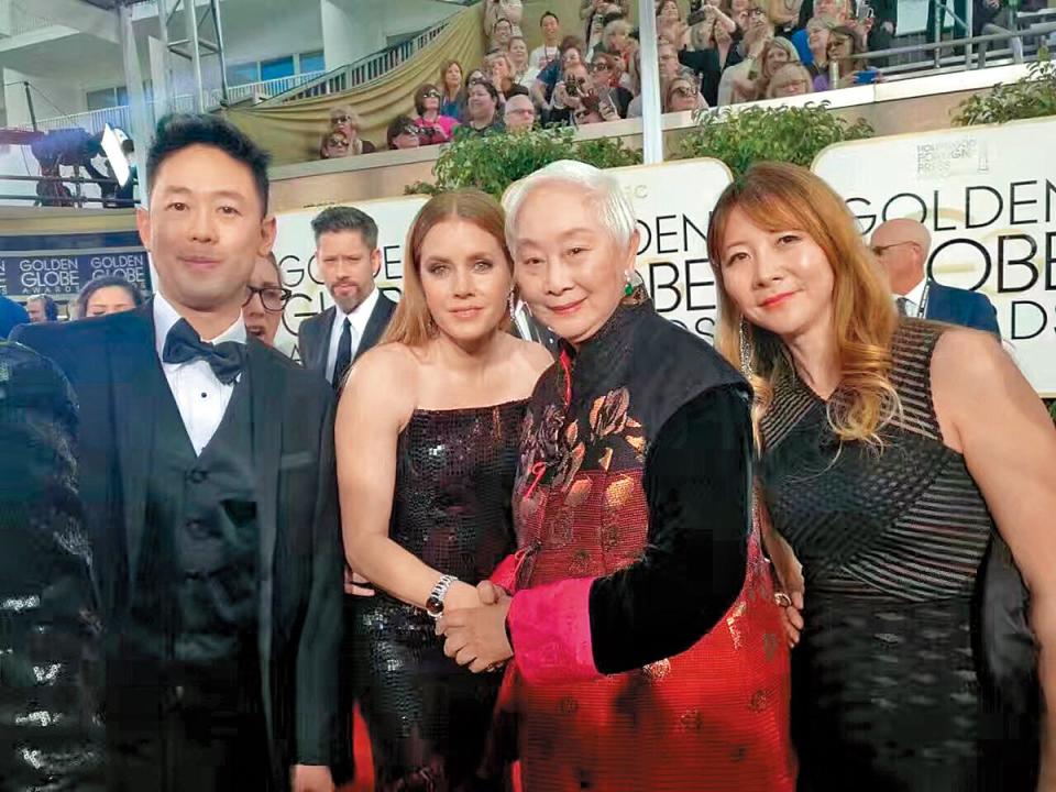 盧燕以好萊塢外籍記者協會成員身分出席金球獎，女星艾美亞當斯（左）和她親切握手。（盧燕提供）