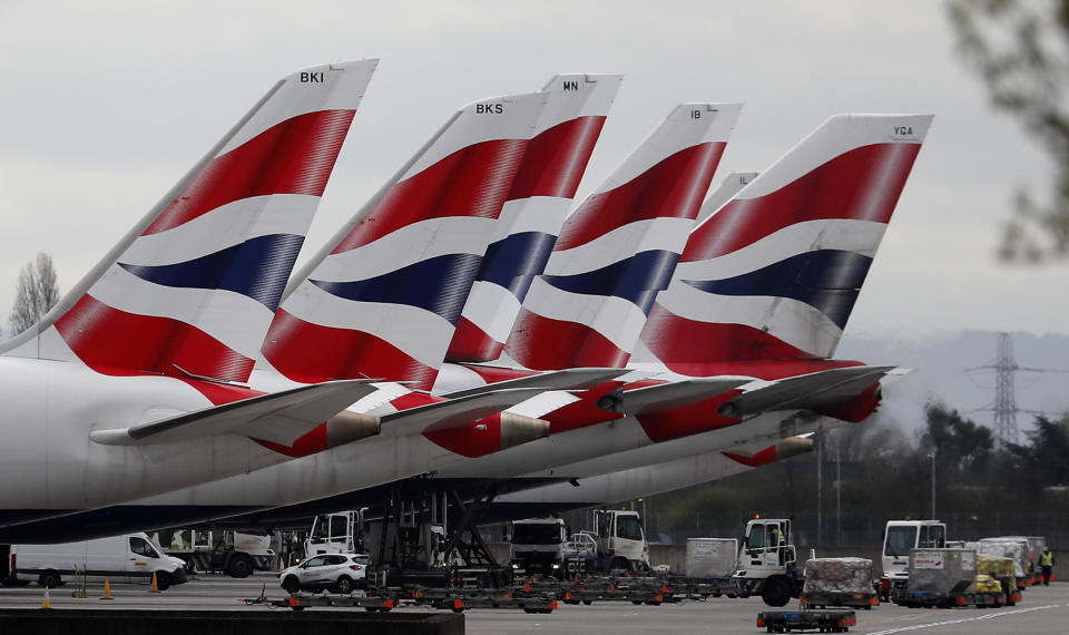 FILE - In this Wednesday, March 18, 2020 file photo, British Airways planes parked at Terminal 5 Heathrow airport in London. The airline has grounded much of its fleet and cabin crew, ground staff and engineers are among over 35,0000 employees facing job suspensions, it was reported on Thursday, April 2, 2020. For most people, the new coronavirus causes only mild or moderate symptoms, such as fever and cough. For some, especially older adults and people with existing health problems, it can cause more severe illness, including pneumonia. (AP Photo/Frank Augstein, File)