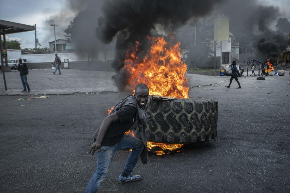 A protester adds a tire to a burning barricade during a protest against fuel price hikes and to demand that Haitian Prime Minister Ariel Henry step down, in Port-au-Prince, Haiti, Friday, Sept. 16, 2022. (AP Photo/Odelyn Joseph)