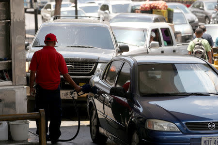 A worker pumps fuel into a vehicle at a state oil company PDVSA's gas station in Caracas, Venezuela May 17, 2019. REUTERS/Ivan Alvarado