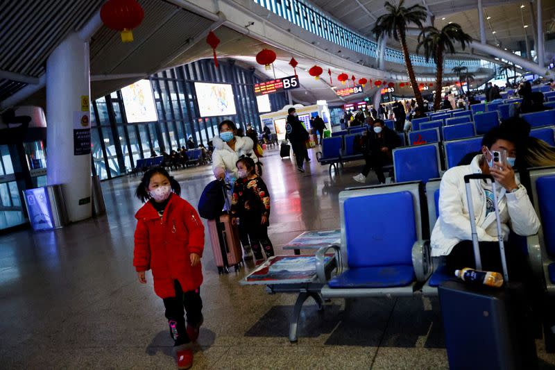 FOTO DE ARCHIVO. Un niño camina mientras la gente espera con sus maletas en una estación de tren, en medio del brote de la enfermedad por coronavirus (COVID-19), en Wuhan, provincia de Hubei, China