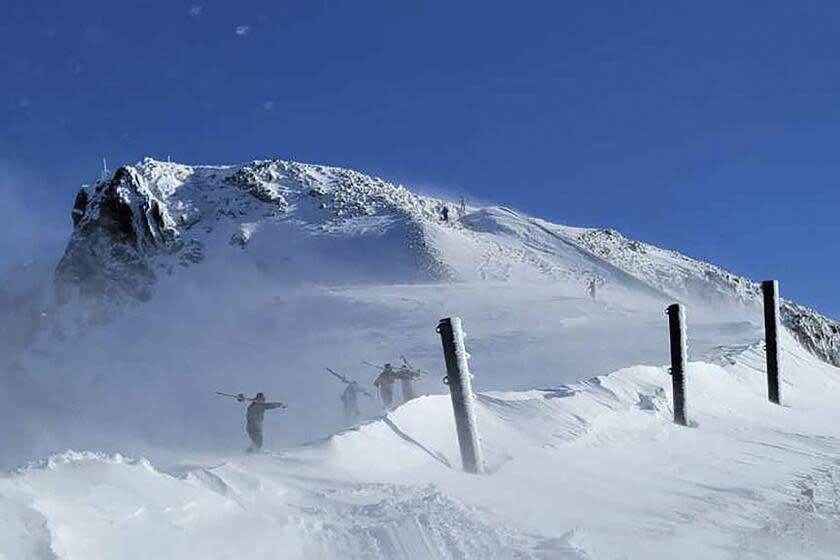 ADDS NAME OF SKI RESORT - Skiers climb to the top of a mountain near Palisades Tahoe, a California ski resort near Lake Tahoe, on Thursday, Jan. 11, 2024, in Calif. After closing down every lift and trail in the avalanche's aftermath, Palisades Tahoe reopened many runs on Thursday. But its iconic KT-22 lift, which serves the area of mostly expert runs where the slide occurred, remained closed while crews worked to clear a road to enable snowcats and snowmobiles to enter and clean up. (Mark Sponsler via AP)