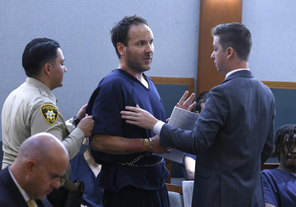 Jon Roger Letzkus, center, who was arrested for firing a gun from a high rise on New Year's Eve morning, speaks to Dallas Anselmo, right, a deputy public defender, an attorney for Letzkus, as he is led out of the courtroom after a hearing at the Regional Justice Center, on Wednesday, Jan. 3, 2024, in Las Vegas. (Bizuayehu Tesfaye/Las Vegas Review-Journal via AP)