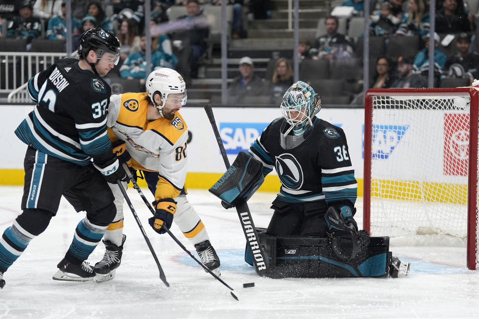 San Jose Sharks goaltender Kaapo Kahkonen (36) blocks a shot by Nashville Predators center Tommy Novak (82) as Sharks' Calen Addison (33) defends during the second period of an NHL hockey game Saturday, Feb. 24, 2024, in San Jose, Calif. (AP Photo/Tony Avelar)