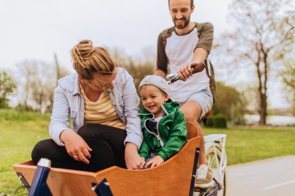 Eine Familie fährt übers Land mit einem Lastenrad.