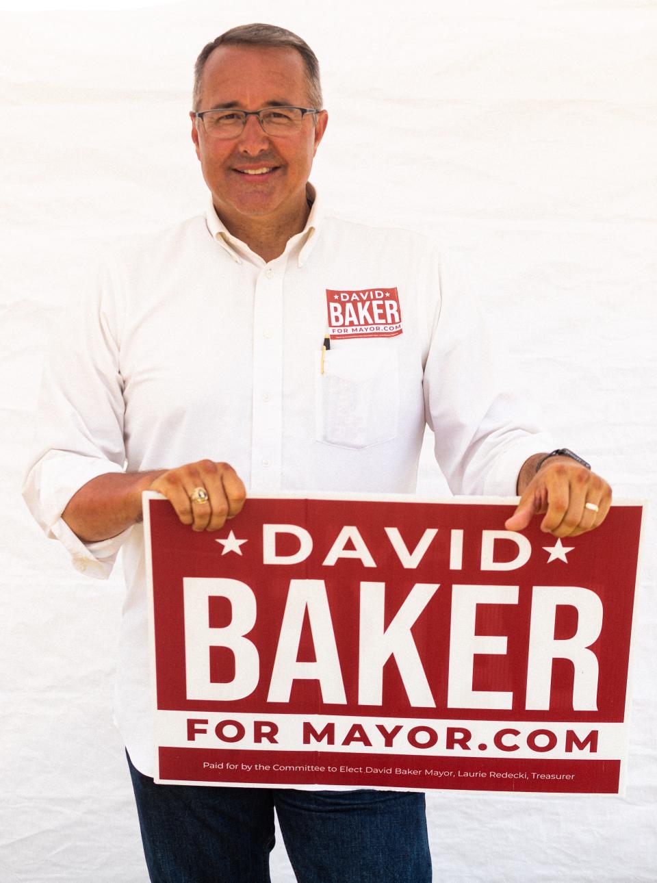 David Baker stands at his booth on the campaign line outside of Maury County Election Commission in Columbia, Tenn., July 22, 2022.