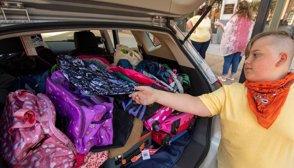 Curvin Coxen begins to unload gift bags from his mother's SUV in front of York County Office of Children, Youth & Families. The batman bag on top was donated by his best friend.