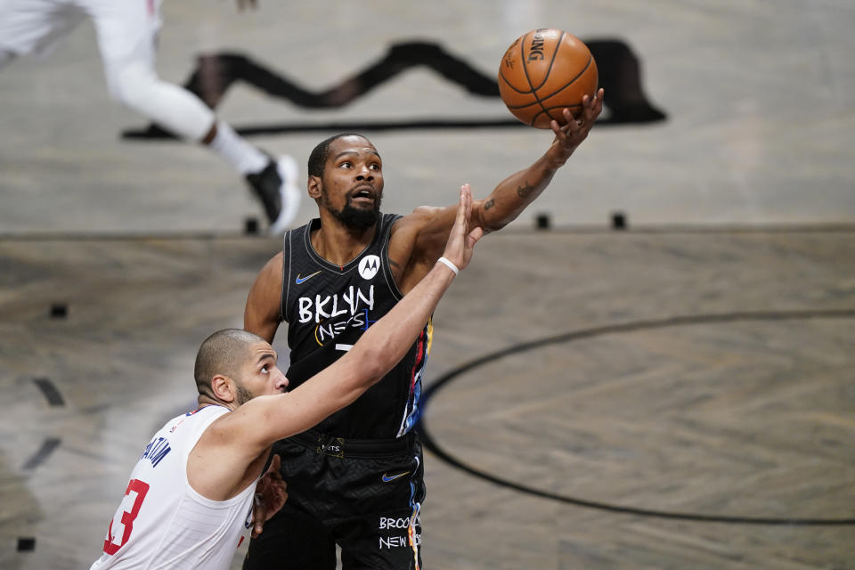 Los Angeles Clippers forward Nicolas Batum defends Brooklyn Nets forward Kevin Durant as Durant reaches for the ball.