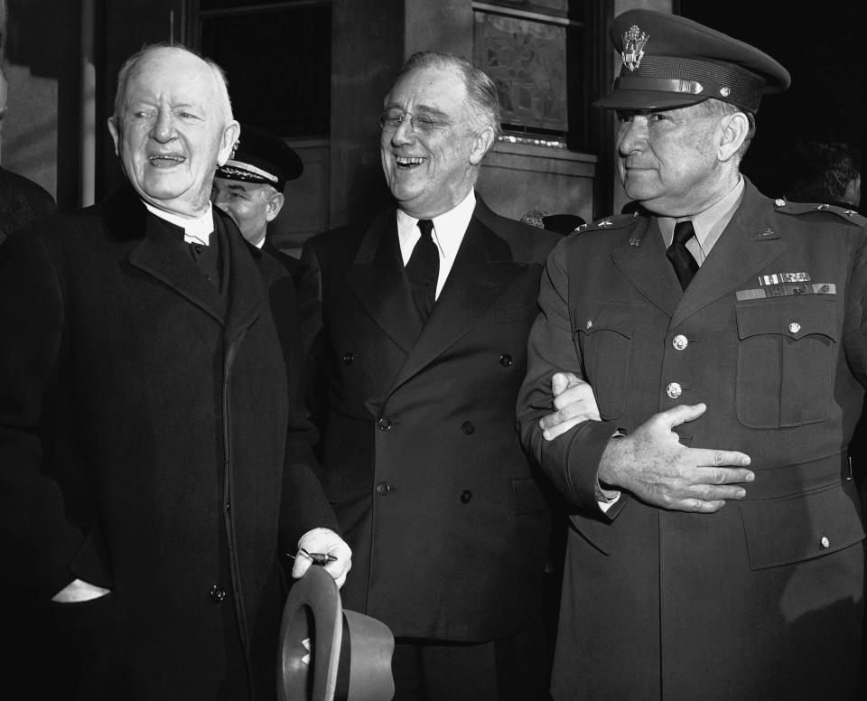 FILE - In this March 4, 1942 file photo, President Franklin Roosevelt leaves after prayer services at St. John's Episcopal Church in Washington, following his custom of attending church on each anniversary of his first inauguration on March 4, 1933. As he left the church he stopped to talk with the Rev. Endicott Peabody, left, headmaster emeritus of Groton school. At right is Major General Edwin M. Watson, presidential secretary and military aide. (AP Photo)