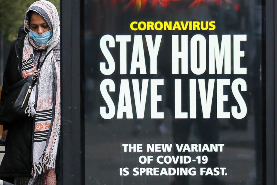 LONDON, UNITED KINGDOM - 2021/01/10: A woman walks past the Government's 'Stay Home, Save Lives' Covid-19 publicity campaign poster in London, as the number of cases of the mutated variant of the SARS-Cov-2 virus continues to spread around the country. (Photo by Dinendra Haria/SOPA Images/LightRocket via Getty Images)