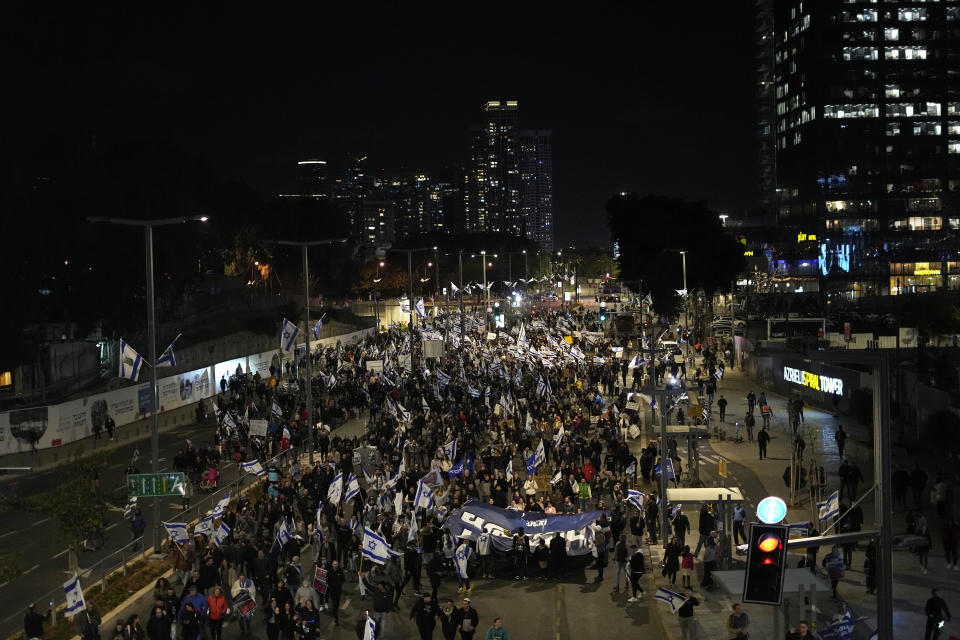 Right-wing Israelis march on a main road as they rally in support of Prime Minister Benjamin Netanyahu's government plans to overhaul the judicial system, in Tel Aviv, Israel, Thursday, March 30, 2023. (AP Photo/Ariel Schalit)