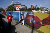 FILE - In this Feb. 4, 2021, file photo, Kansas City Chiefs fans walk past Raymond James Stadium ahead of Super Bowl 55 in Tampa, Fla. The city is hosting Sunday's Super Bowl football game between the Tampa Bay Buccaneers and the Kansas City Chiefs. (AP Photo/Charlie Riedel, File)