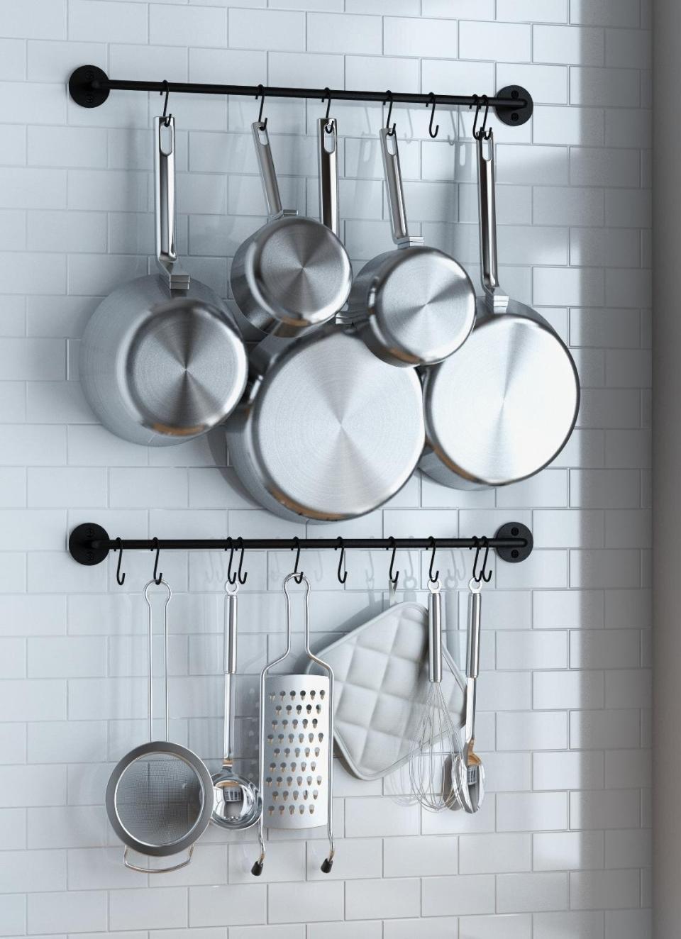 The pan rack mounted on tile with cookware hanging.