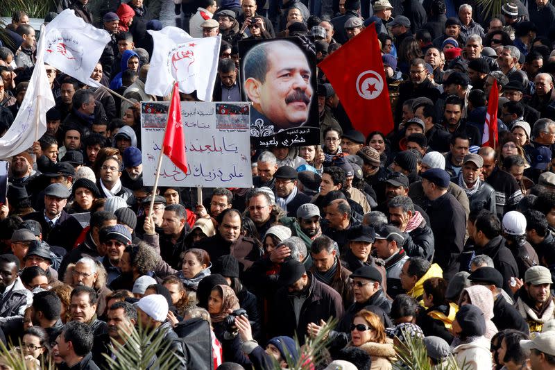 FILE PHOTO: Tunisians hold a placard with an image of the late secular opposition leader Chokri Belaid during his funeral procession in the Jebel Jelloud district in Tunis