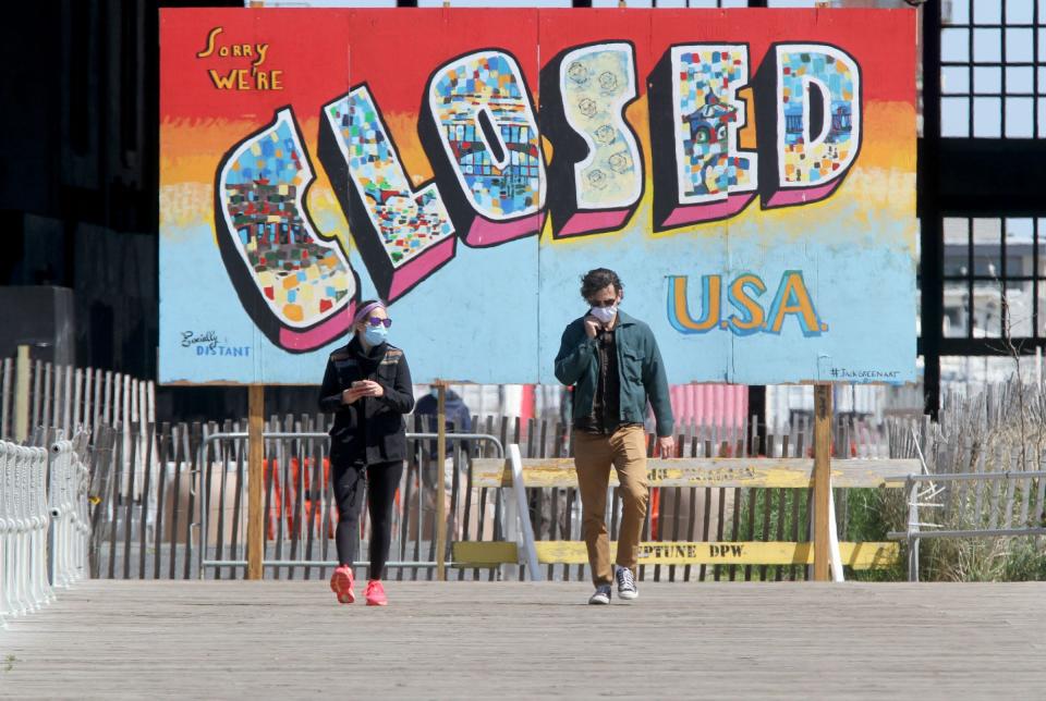 Danielle Glassman, New Brunswick, and Paul Lavadera, Long Branch, walk along the north end of the Ocean Grove, NJ, boardwalk, May 5, 2020, with a “Sorry We’re Closed” sign behind them.  The art is signed by #JackGreenArt and stands on the border with Asbury Park near the Casino building.