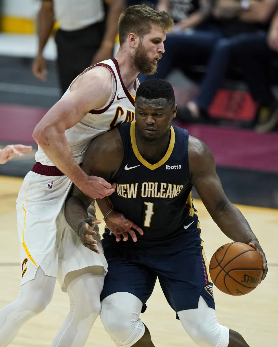 New Orleans Pelicans' Zion Williamson, right, drives to the basket against Cleveland Cavaliers' Dean Wade in the second half of an NBA basketball game, Sunday, April 11, 2021, in Cleveland. (AP Photo/Tony Dejak)