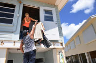 <p>Ely Chavez hands clothes to her husband Kevin Chavez as they salvage belongings from their damaged home following Hurricane Irma in the Tavernier area located in the Florida Keys on Sept. 12, 2017 in Tavernier, FL. The family was able to get back to see their home for the first time today. Their porch and deck was destroyed leaving them to use a ladder to get to the second floor. “Didn’t expect it to be this bad”, Kevin said while referring to his home. (Photo: Matt McClain/The Washington Post via Getty Images) </p>