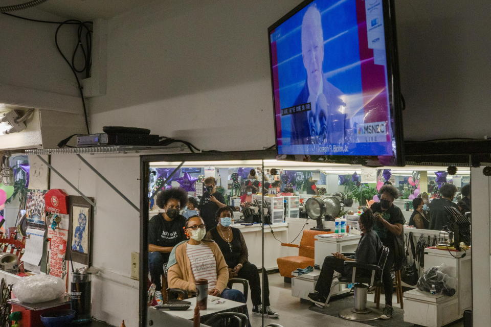 Stylist Dia Clyburn (L), the niece of U.S. Rep. Jim Clyburn, watches the televised inauguration of President Joe Biden with clients at Clyburn's Beauty Salon in Sumter, South Carolina, U.S. January 20, 2021. Picture taken January 20, 2021.  REUTERS/Micah Green