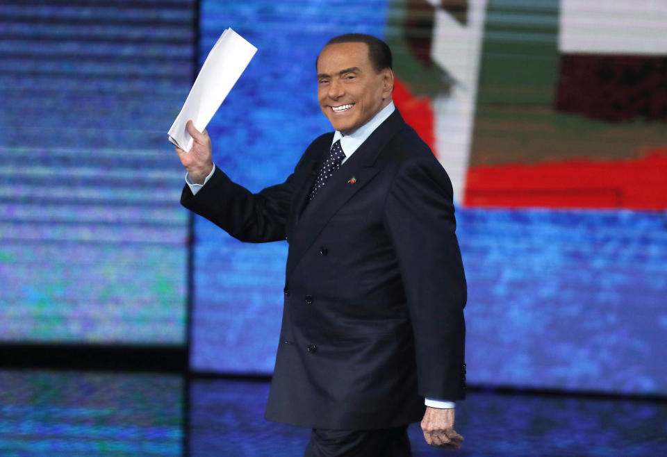 FILE - Former Italian premier Silvio Berlusconi waves as he arrives for the Italian State RAI TV program "Che Tempo che Fa", in Milan, Italy, on Nov. 26, 2017. Berlusconi, the boastful billionaire media mogul who was Italy's longest-serving premier despite scandals over his sex-fueled parties and allegations of corruption, died, according to Italian media. He was 86. (AP Photo/Antonio Calanni, File)