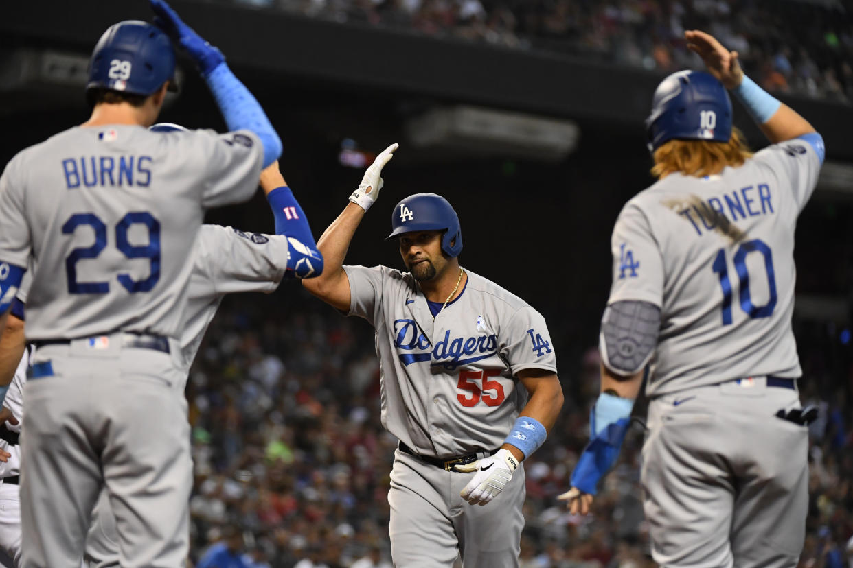 Albert Pujols of the Los Angeles Dodgers celebrates with Justin Turner and Andy Burns after hitting a three-run home run. (Photo by Norm Hall/Getty Images)