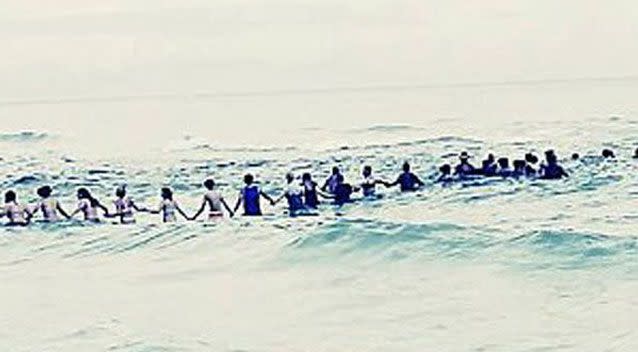 Eighty beachgoers linked arms to save the family. Source: Facebook